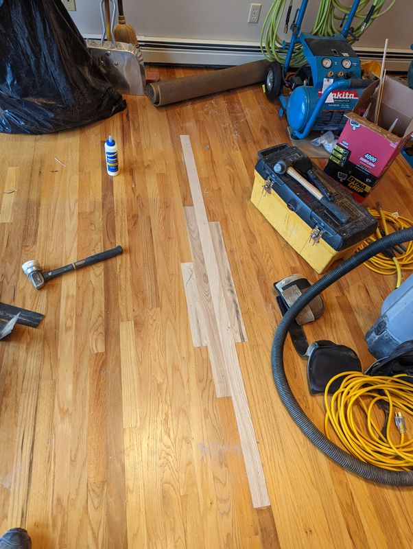 Completed hardwood floor repair with matched grain and finish
