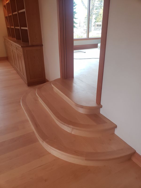 Rounded bullnose step connecting rooms with hardwood transition